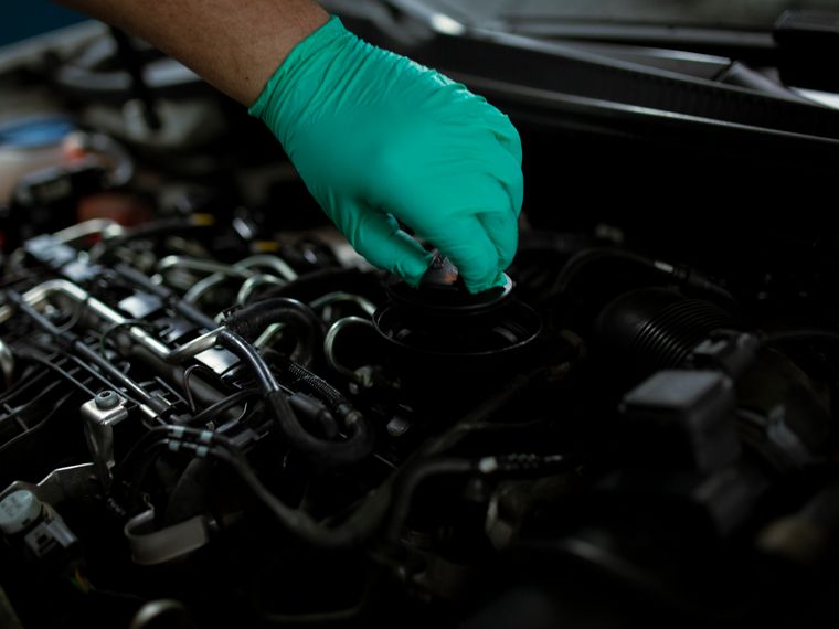 Oil change underway on a lifted vehicle